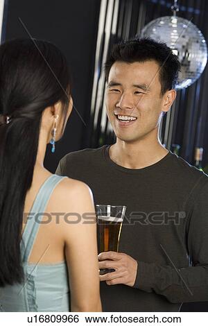 Man with beer talking to woman in nightclub View Large Photo Image Stock Photograph - Man with beer talking to woman in nightclub. Fotosearch