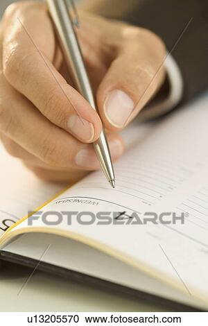 Man writing in an appointment book View Large Photo Image Stock Image - Man writing in an appointment book. Fotosearch