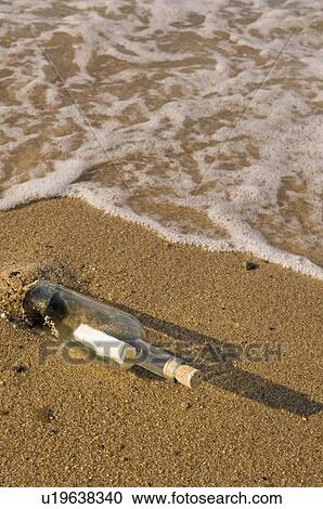 Stock Image - Message in a bottle on beach. Fotosearch