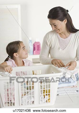 Mother and daughter doing laundry View Large Photo Image Stock Photograph - Mother and daughter doing laundry. Fotosearch