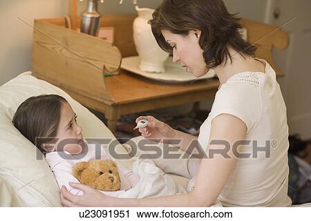 Mother checking young daughter’s temperature with thermometer View Large Photo Image Stock Image - Mother checking young daughter’s temperature with thermometer. Fotosearch