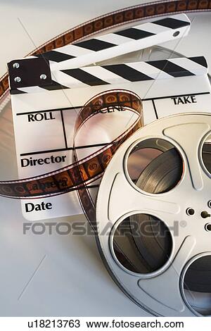 Movie reel with film and clapboard View Large Photo Image Stock Image - Movie reel with film and clapboard. Fotosearch