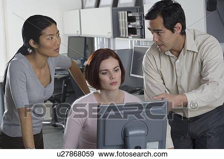Office workers conferring at computer View Large Photo Image Stock Photo - Office workers conferring at computer. Fotosearch