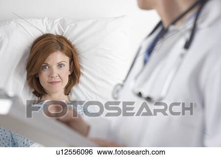Stock Photograph - Patient with doctor and chart. Fotosearch