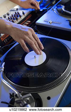 Stock Image - Person mixing music in a nightclub. Fotosearch