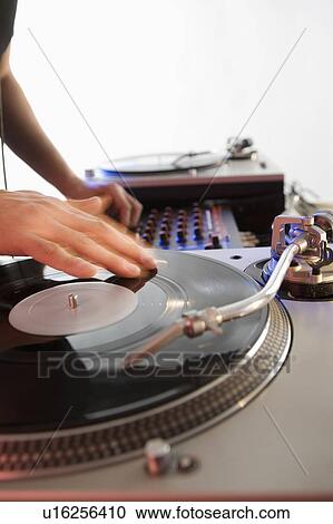 Stock Image - Person mixing sound from records. Fotosearch