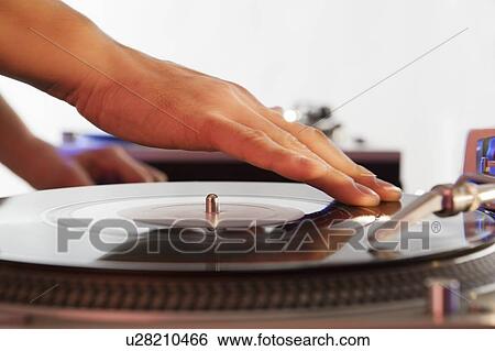 Stock Photograph - Person mixing sound from records. Fotosearch
