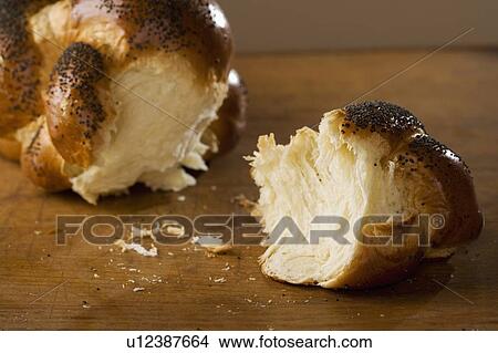 Picture - Piece of Challah bread broken off of loaf. Fotosearch