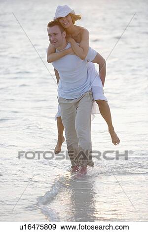 Stock Photo - Playful couple at the beach. Fotosearch