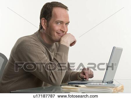 Portrait of a man at his computer View Large Photo Image Stock Photo - Portrait of a man at his computer. Fotosearch