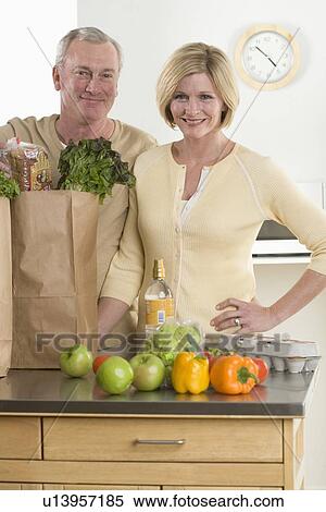 Portrait of couple unloading groceries View Large Photo Image Stock Photography - Portrait of couple unloading groceries. Fotosearch