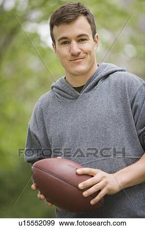 Stock Photo - Portrait of man holding football. Fotosearch