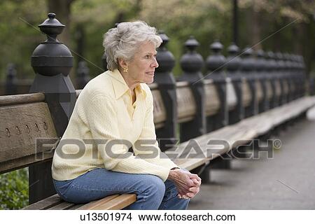 Portrait of woman sitting on park bench View Large Photo Image Picture - Portrait of woman sitting on park bench. Fotosearch