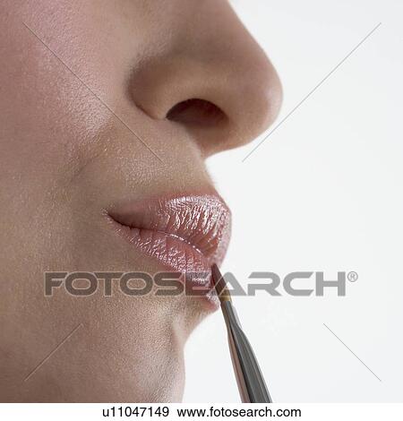 Stock Photo - Profile of woman's lips with brush. Fotosearch