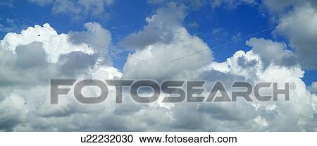 Puffy white clouds against a blue sky View Large Photo Image Stock Image - Puffy white clouds against a blue sky. Fotosearch
