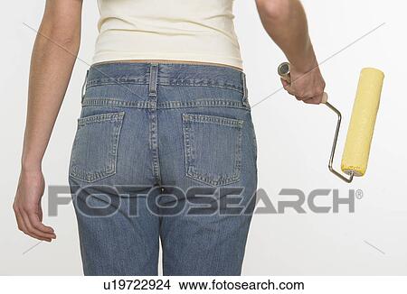 Rear view of woman holding paint roller View Large Photo Image Picture - Rear view of woman holding paint roller. Fotosearch
