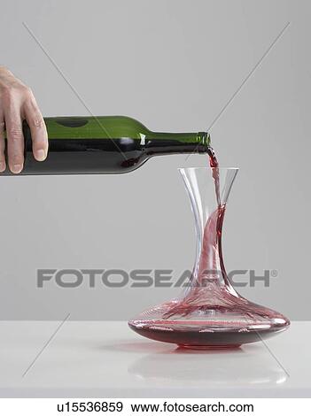 Stock Photo - Red wine pouring into carafe. Fotosearch
