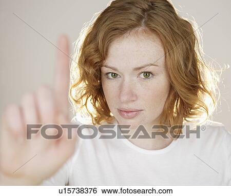 Redhead holding up one finger View Large Photo Image Stock Photograph - Redhead holding up one finger. Fotosearch