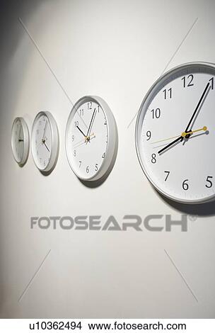 Row of clocks hanging on wall View Large Photo Image Picture - Row of clocks hanging on wall. Fotosearch