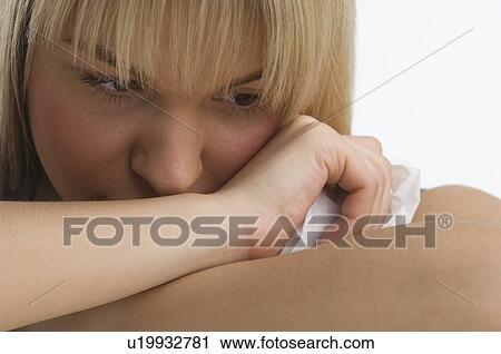 Stock Image - Sad woman with chin resting on her arms. Fotosearch
