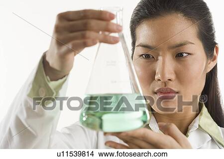 Scientist looking at glass beaker View Large Photo Image Picture - Scientist looking at glass beaker. Fotosearch