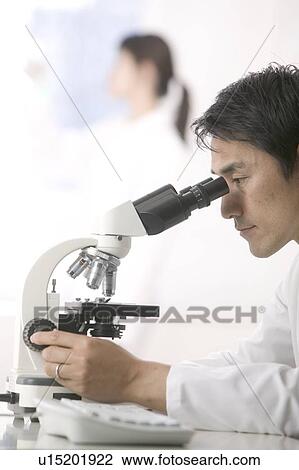 Scientist looking in microscope View Large Photo Image Stock Image - Scientist looking in microscope. Fotosearch