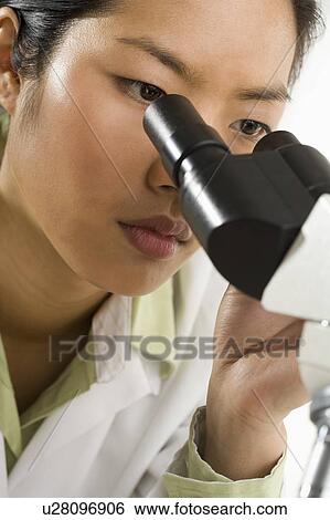 Stock Photograph - Scientist looking through microscope. Fotosearch
