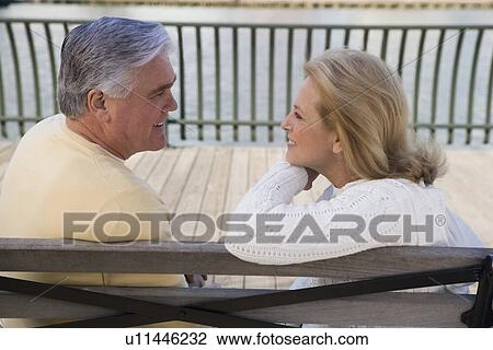Senior couple sitting on bench outdoors View Large Photo Image Stock Image - Senior couple sitting on bench outdoors. Fotosearch