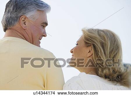Senior couple smiling and looking at each other outdoors View Large Photo Image Picture - Senior couple smiling and looking at each other outdoors. Fotosearch