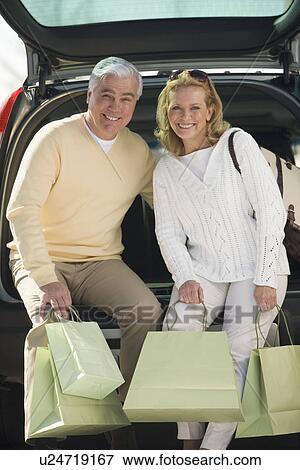 Stock Photo - Senior couple with shopping in bags. Fotosearch