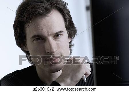 Serious man holding pen View Large Photo Image Stock Image - Serious man holding pen. Fotosearch