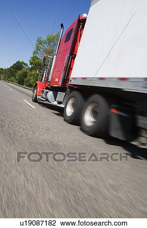 Stock Image - Side angle view of tractor trailer on highway. Fotosearch