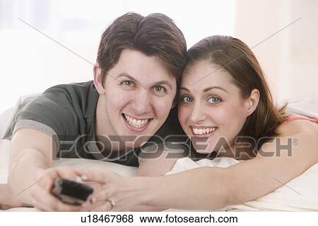Smiling couple with remote control View Large Photo Image Stock Photo - Smiling couple with remote control. Fotosearch