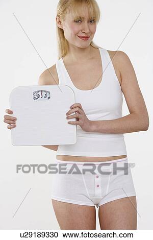 Smiling woman holding scale View Large Photo Image Stock Image - Smiling woman holding scale. Fotosearch