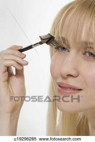 Stock Photography - Smiling woman using cosmetic brush. Fotosearch