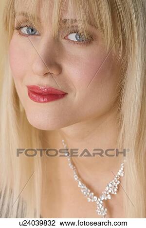 Stock Image - Smiling woman wearing necklace. Fotosearch