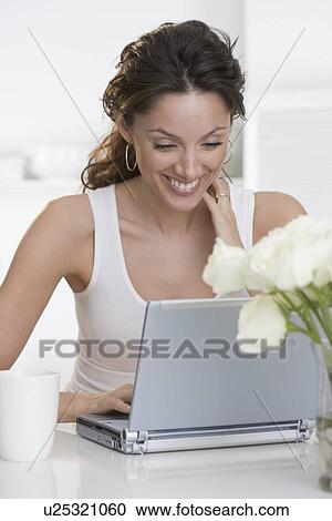 Smiling woman with laptop and cup View Large Photo Image Stock Image - Smiling woman with laptop and cup. Fotosearch