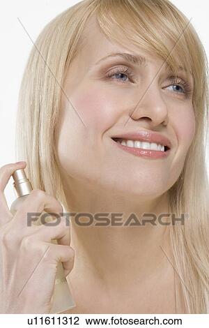 Stock Image - Smiling woman with spray bottle. Fotosearch
