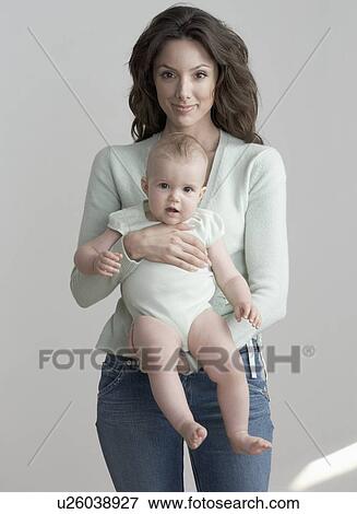Standing woman holding baby View Large Photo Image Stock Photo - Standing woman holding baby. Fotosearch