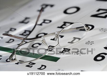 Stock Image - Still life of eye chart and glasses. Fotosearch