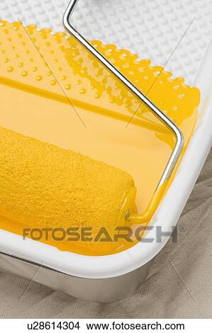 Picture - Still life of paint roller with yellow paint. Fotosearch