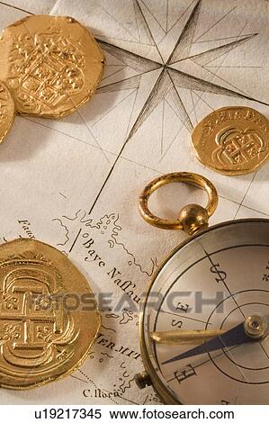 Stock Photography - Still life of pieces of gold map and compass. Fotosearch