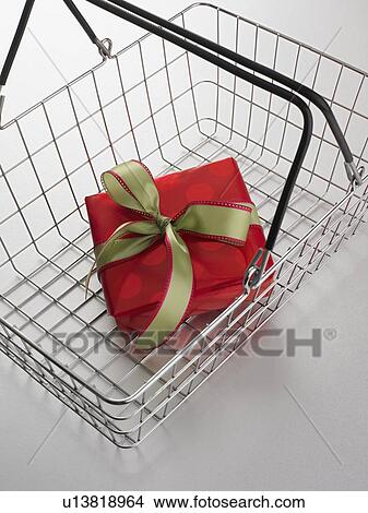 Picture - Still life of shopping basket with gift inside. Fotosearch