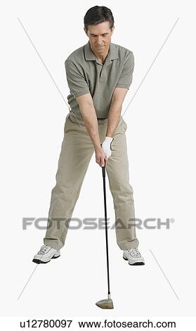Studio shot of man playing golf View Large Photo Image Stock Photo - Studio shot of man playing golf. Fotosearch