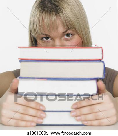 Studio shot of woman behind stack of books View Large Photo Image Stock Photography - Studio shot of woman behind stack of books. Fotosearch