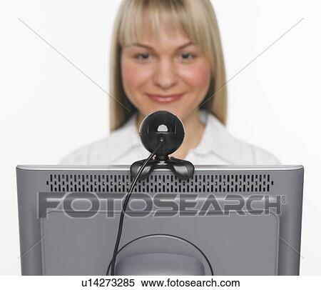 Stock Photography - Studio shot of woman using webcam. Fotosearch