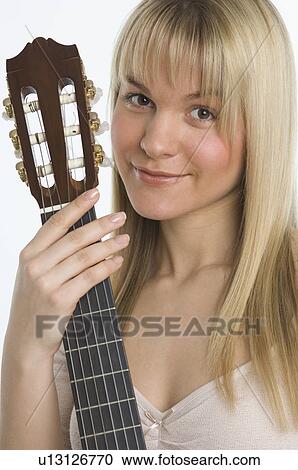 Stock Image - Studio shot of woman with guitar. Fotosearch