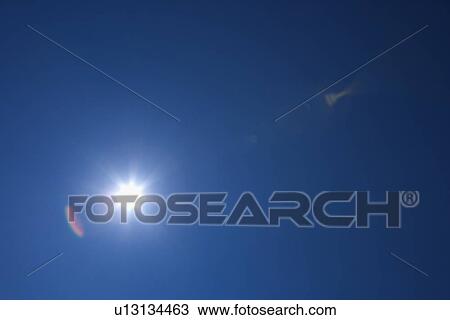 Stock Image - Sun in blue sky. Fotosearch