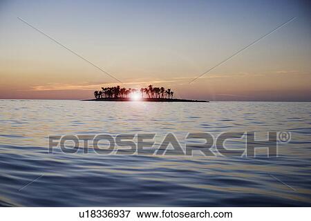 Stock Photo - Sunset over tropical island. Fotosearch