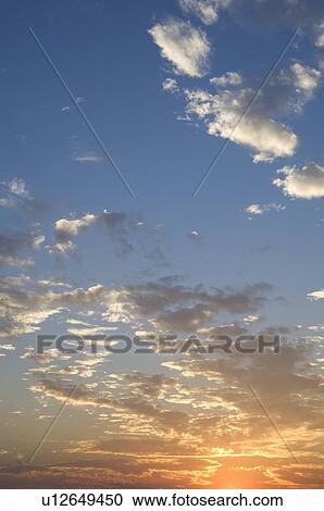 Stock Image - Sunset with puffy clouds. Fotosearch